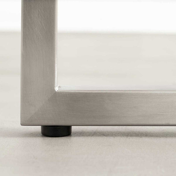 KANADEMONOの配線孔BROCK&TRAY付きのラバーウッド材アッシュグレー天板とT型ステンレス脚を組み合わせたテーブル（アジャスター部分）