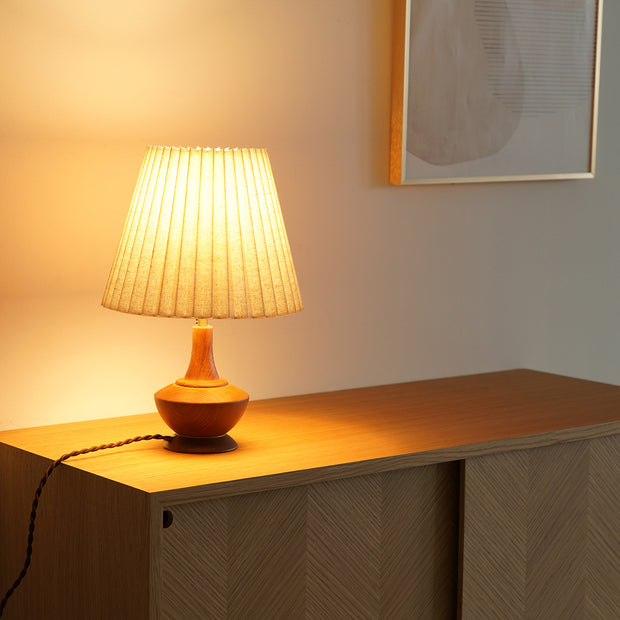 プリーツ状のファブリックシェードが心地よい明かりを灯すナチュラルなテーブルライト（使用例点灯時）