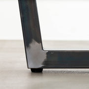 KANADEMONOの配線孔BROCK&TRAY付きのラバーウッド材ブラウン天板とマットクリア塗装仕上げのブラックのトラぺゾイド鉄脚を組み合わせたテーブル（アジャスター部分）