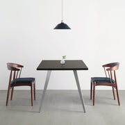 Gemoneのシックなブラックブラウンのラバーウッド材と美しい質感が際立つフラットピンのステンレス脚を組み合わせた重厚感のあるテーブル（使用例２）