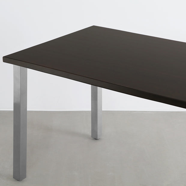 Gemoneのシックなブラックブラウンのラバーウッド材と美しい質感が際立つスクエアバーのステンレス脚を組み合わせた重厚感のあるテーブル(斜め)