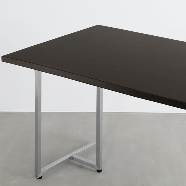 Gemoneのシックなブラックブラウンのラバーウッド材と美しい質感が際立つT型ステンレス脚を組み合わせた重厚感のあるテーブル（斜め）
