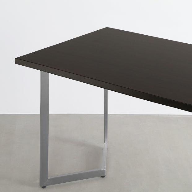 Gemoneのシックなブラックブラウンのラバーウッド材と美しい質感が際立つW型ステンレス脚を組み合わせた重厚感のあるテーブル（斜め）
