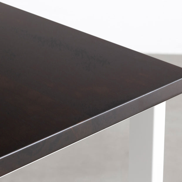 KANADEMONOのワイヤーバスケット付きのラバーウッド材ブラックブラウンカラー天板にマットホワイトのレクタングル鉄脚を組み合わせたテーブル（天板寄り）