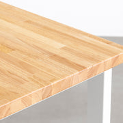 KANADEMONOのワイヤーバスケット付きのラバーウッド材ナチュラルカラー天板にマットホワイトのレクタングル鉄脚を組み合わせたテーブル（天板寄り）