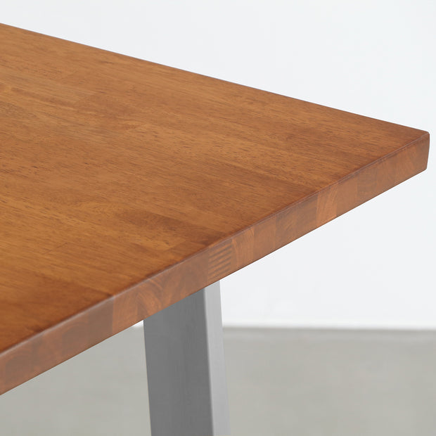 Gemoneの艶やかなチークブラウンのラバーウッド材と美しい質感が際立つベル型ステンレス脚を組み合わせた重厚感のあるテーブル（天板クローズ）
