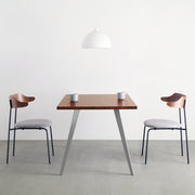 Gemoneの艶やかなチークブラウンのラバーウッド材と美しい質感が際立つフラットピンのステンレス脚を組み合わせた重厚感のあるテーブル(使用例2)
