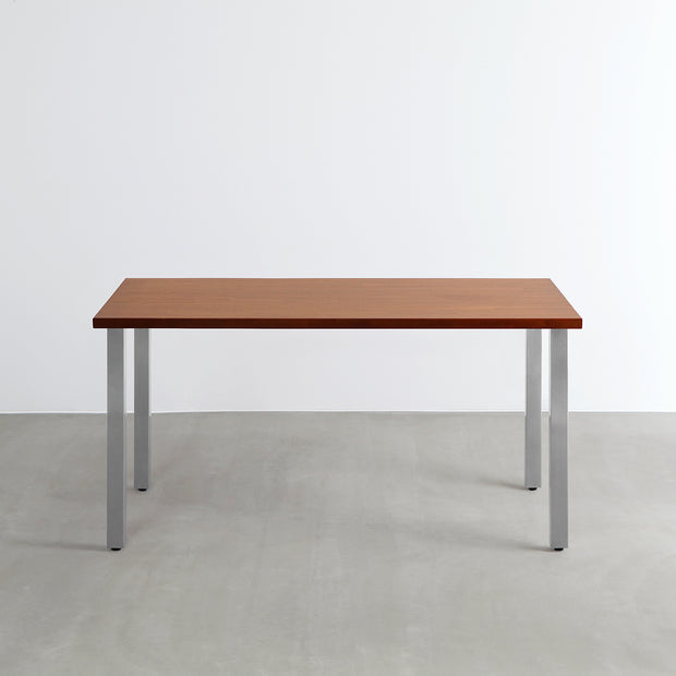 Gemoneの艶やかなチークブラウンのラバーウッド材と美しい質感が際立つスクエアバーのステンレス脚を組み合わせた重厚感のあるテーブル(正面)