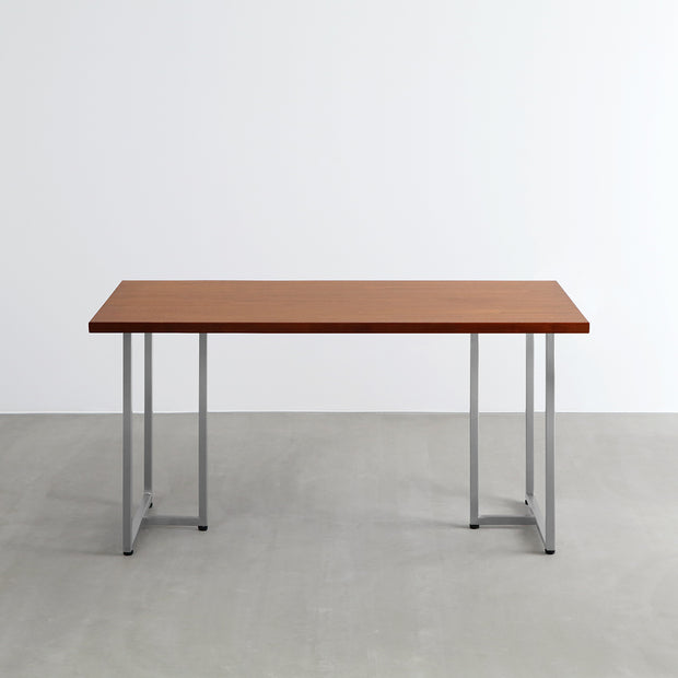 Gemoneの艶やかなチークブラウンのラバーウッド材と美しい質感が際立つT型ステンレス脚を組み合わせた重厚感のあるテーブル（正面）