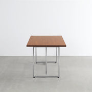 Gemoneの艶やかなチークブラウンのラバーウッド材と美しい質感が際立つT型ステンレス脚を組み合わせた重厚感のあるテーブル（横向き）