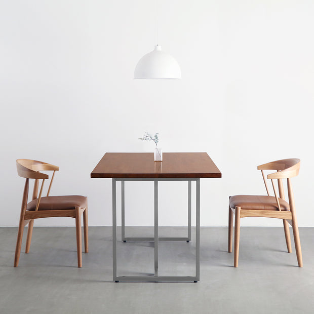 Gemoneの艶やかなチークブラウンのラバーウッド材と美しい質感が際立つT型ステンレス脚を組み合わせた重厚感のあるテーブルの使用例2