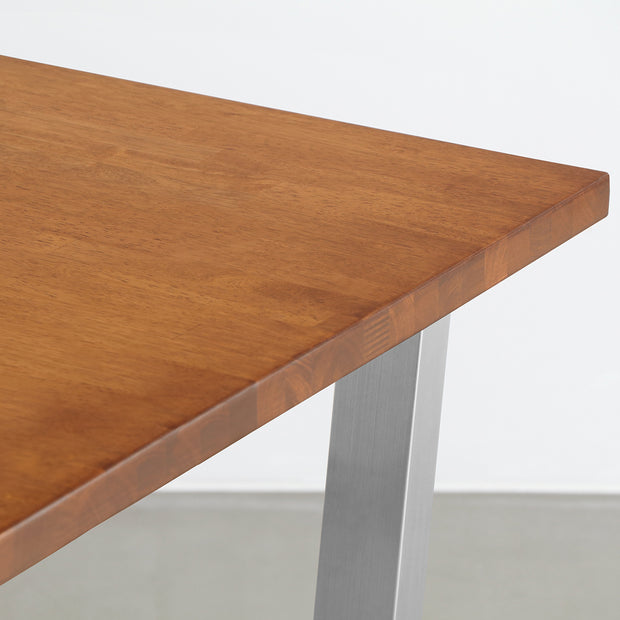Gemoneの艶やかなチークブラウンのラバーウッド材と美しい質感が際立つトラペゾイドのステンレス脚を組み合わせた重厚感のあるテーブル(天板)