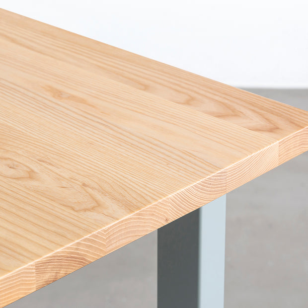 KANADEMONOのホワイトアッシュ無垢材の天板とユーカリプタスのカラースクエア脚を組み合わせたテーブル（天板角）