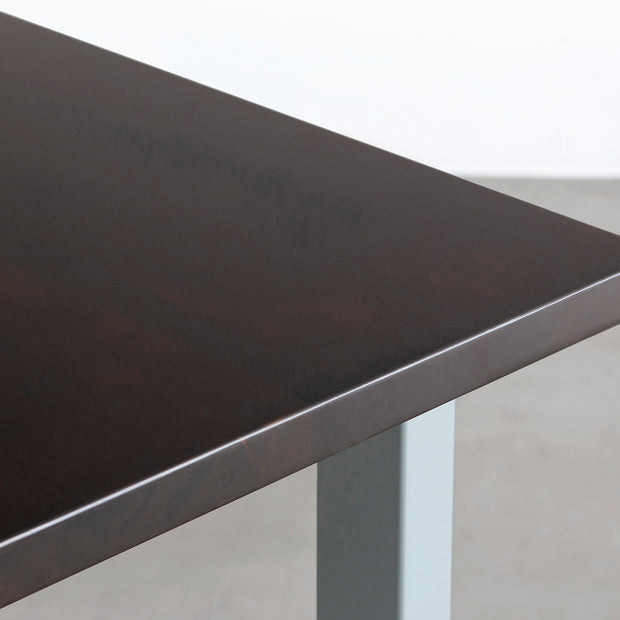 KANADEMONOのラバーウッド材ブラックブラウンの天板とユーカリプタスのカラースクエア脚を組み合わせたテーブル（天板角）