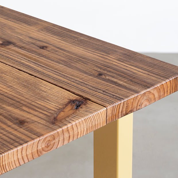 KANADEMONOのヴィンテージ加工した杉無垢材の天板とマリーゴールドのカラースクエア脚を組み合わせたテーブル（天板角）