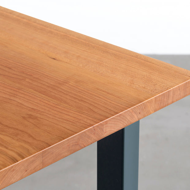 KANADEMONOのブラックチェリー無垢材の天板とローズマリーのカラースクエア脚を組み合わせたテーブル（天板角）