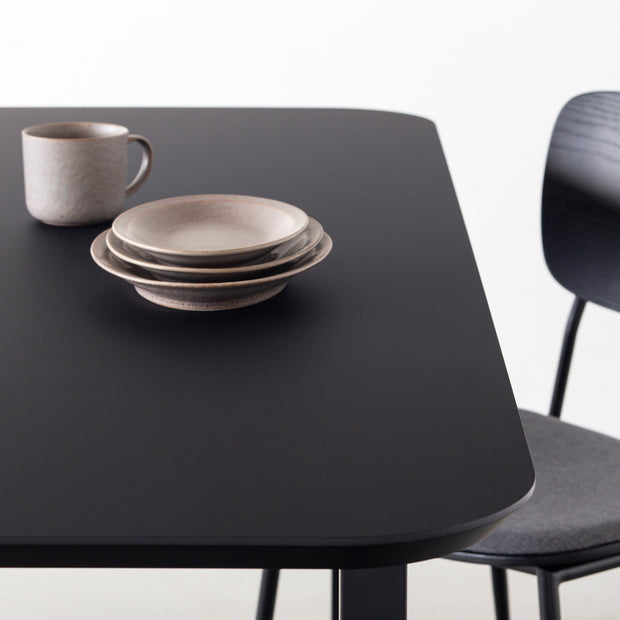 KanademonoのFENIX 天板ブラックにマットブラックのスクエア鉄脚を組み合わせた、優れた性能と美しさを併せもつ新しいテーブル（ダイニング使用例2）