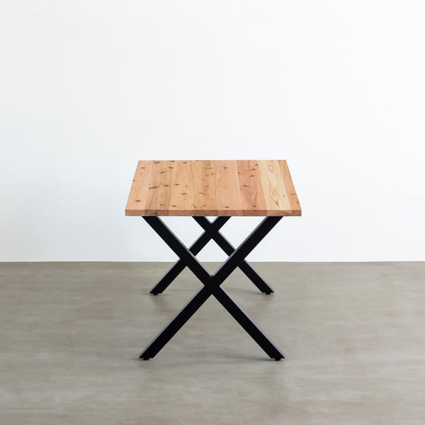 かなでものの杉無垢材とマットブラックのX型の鉄脚を使用したシンプルモダンなデザインのテーブル（横からのアングル）