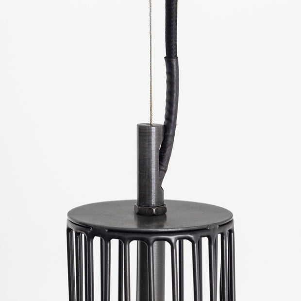 ブラックのアイアンワイヤーで作成された筒状のシェードがインダストリアルな雰囲気のペンダントライト（上部）