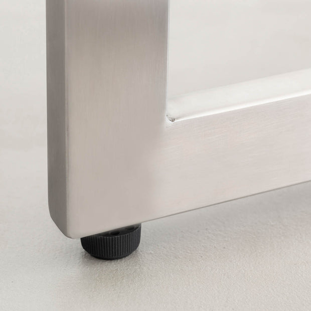 KANADEMONOのナノテクノロジー素材を使用したネイビーのFENIX天板とWラインのステンレス脚を組み合わせた優れた性能と美しさを併せもつ新しいテーブル（アジャスター部分）