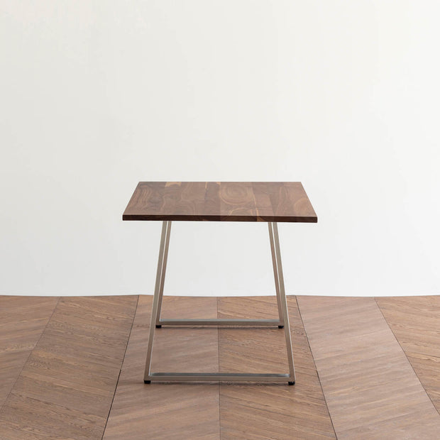Gemoneのウォルナット天板とBell型ステンレス脚を組み合わせた重厚感のあるテーブル（横向き）