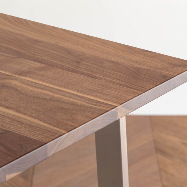 Gemoneのウォルナット天板とBell型ステンレス脚を組み合わせた重厚感のあるテーブル（天板クローズアップ）