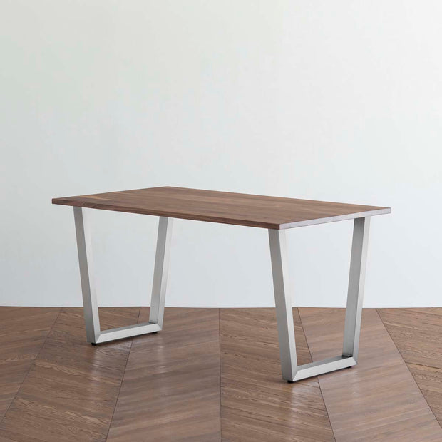 Gemoneのウォルナット天板とトラペゾイド型ステンレス脚を組み合わせた重厚感のあるテーブル