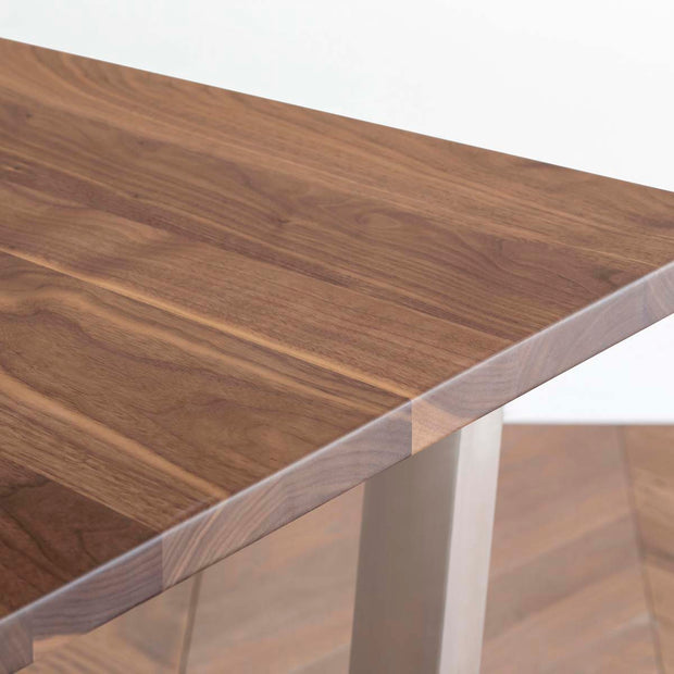 Gemoneのウォルナット天板とトラペゾイド型ステンレス脚を組み合わせた重厚感のあるテーブルの角