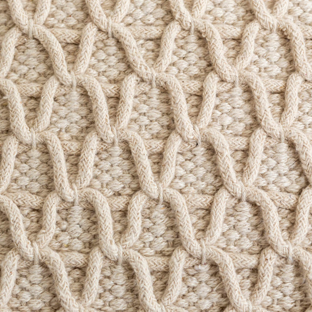 ハンドメイドの立体的な編み目が温かみのあるベージュのクッション（表面）