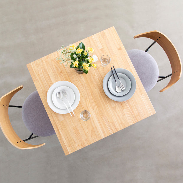 Kanademonoラバーウッドナチュラルのスクエア天板とデザイン性の高いXラインのホワイト脚を組み合わせたカフェテーブル（使用例7）