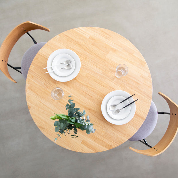 Kanademonoのラバーウッドナチュラル天板とトライアングルホワイト脚4本を組み合わせたラウンド型のカフェテーブル（使用例3）