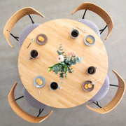 Kanademonoのラバーウッドナチュラル天板とトライアングルホワイト脚4本を組み合わせたラウンド型のカフェテーブル（使用例6）