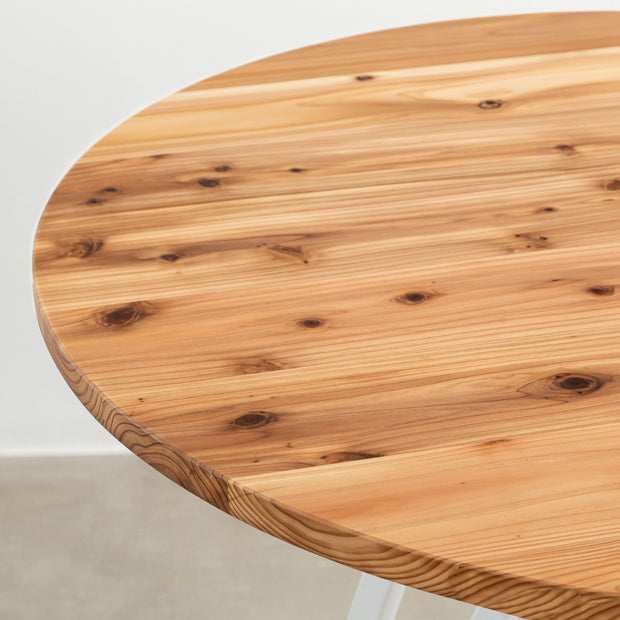 Kanademonoの杉無垢天板とトライアングルホワイト脚3本を組み合わせたラウンド型のカフェテーブル（天板1）