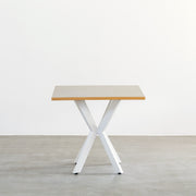 KanademonoリノリウムPebbleのスクエア天板とデザイン性の高いXラインのホワイト脚を組み合わせたカフェテーブル（正面）