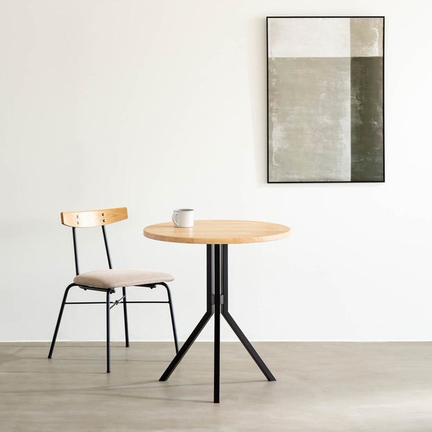 Kanademonoのラバーウッド・ナチュラル天板とスマートなデザインのトライポッド脚を組み合わせたカフェテーブルの使用例