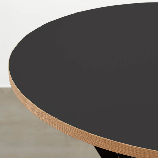 Kanademonoリノリウム・Neroのラウンド天板とデザイン性の高いXラインの脚を組み合わせたカフェテーブル（天板クローズアップ）