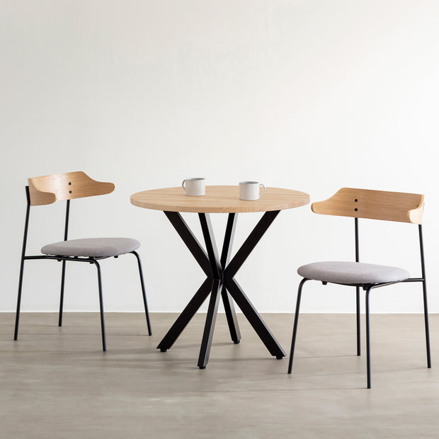 Kanademonoラバーウッド・Ashのラウンド天板とデザイン性の高いXラインの脚を組み合わせたカフェテーブルの使用例1