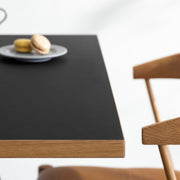 Kanademonoリノリウム Neroのスクエア天板とデザイン性の高いXラインの脚を組み合わせたカフェテーブルの使用例3