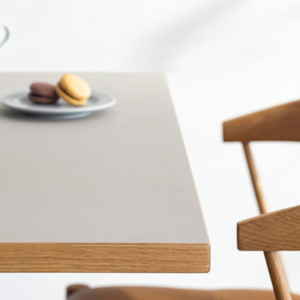 KanademonoリノリウムPebbleのスクエア天板とデザイン性の高いXラインのホワイト脚を組み合わせたカフェテーブル（使用例3）