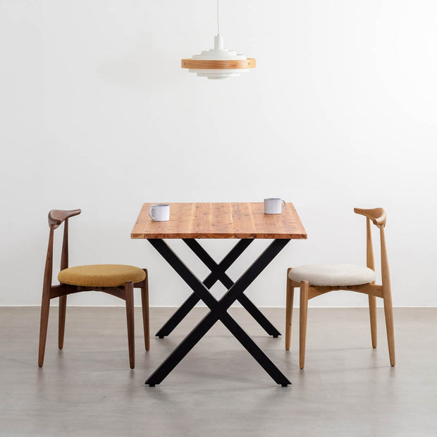 かなでものの杉無垢材とマットブラックのX型の鉄脚を使用したシンプルモダンなデザインのテーブルの使用例1